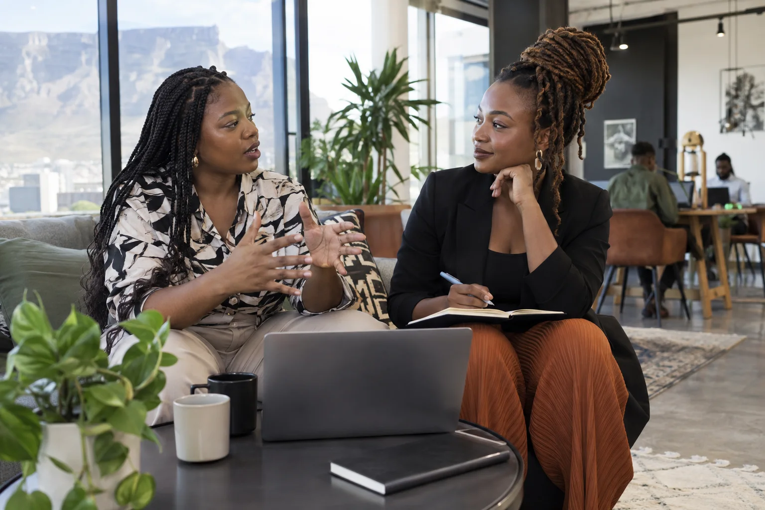 Two South African women tech founders exchanging practical business advice at a light-filled coworking lounge